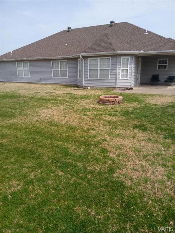 1107 Daffodil St, Sikeston, MO 63801 - back of house with a patio, a fire pit, a yard, and a shingled roof