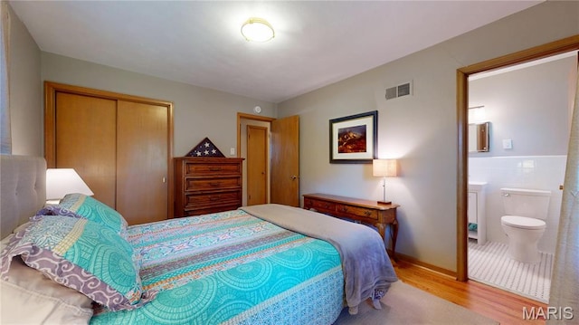 9334 Litzsinger Rd, Rock Hill, MO 63144 - bedroom featuring wood finished floors, a closet, and connected bathroom