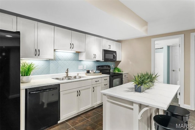 4304 Austin Pass Ct, Saint Charles, MO 63304 - kitchen with black appliances, dark tile patterned floors, decorative backsplash, white cabinetry, and a breakfast bar area