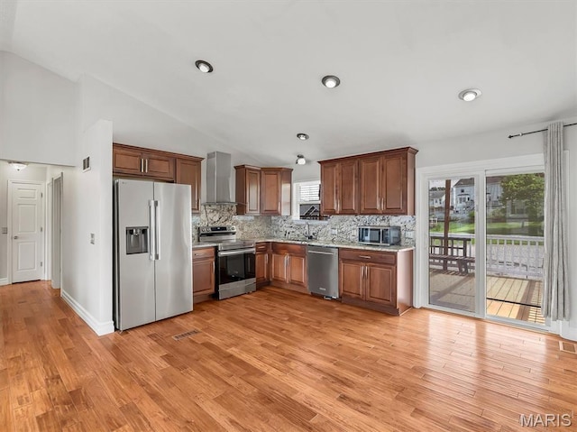 3178 5 Oaks Dr, Arnold, MO 63010 - kitchen with appliances with stainless steel finishes, wall chimney range hood, decorative backsplash, light wood-style floors, and vaulted ceiling