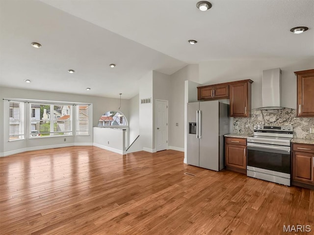 3178 5 Oaks Dr, Arnold, MO 63010 - kitchen featuring wall chimney exhaust hood, stainless steel appliances, lofted ceiling, backsplash, and light wood-type flooring