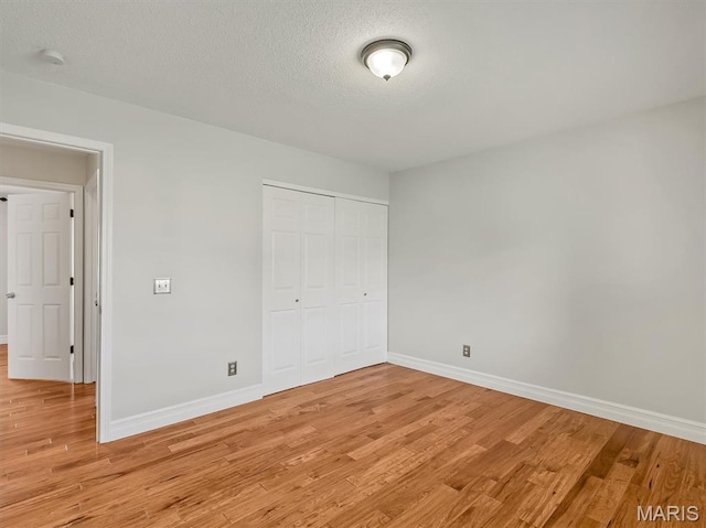 3178 5 Oaks Dr, Arnold, MO 63010 - unfurnished bedroom featuring light wood-style flooring, a closet, and a textured ceiling