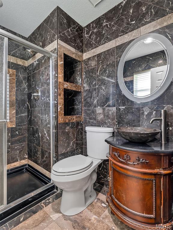3178 5 Oaks Dr, Arnold, MO 63010 - bathroom with tile walls, vanity, a stall shower, and a textured ceiling