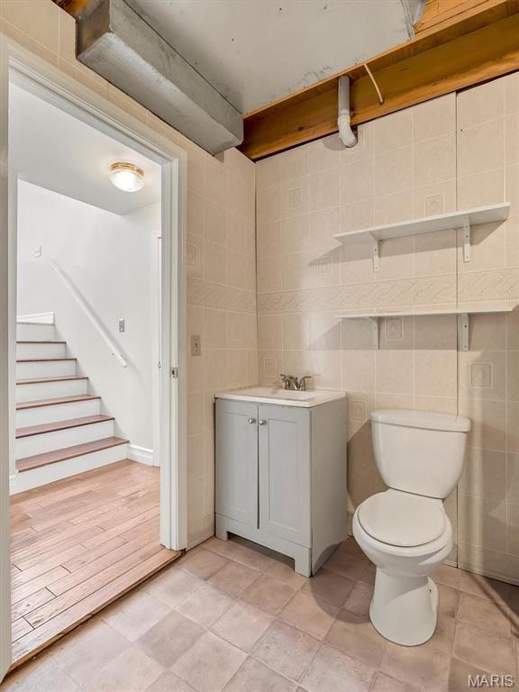3178 5 Oaks Dr, Arnold, MO 63010 - half bathroom featuring vanity, tile walls, and tile patterned flooring