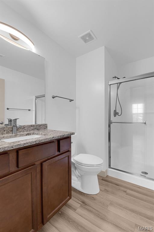 1531 Piedmont Cir Unit 1531, Saint Peters, MO 63304 - bathroom featuring vanity, wood finished floors, and a shower stall