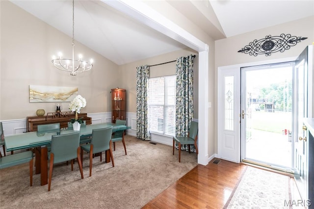 221 Meriwether Lewis Dr, Ofallon, MO 63368 - dining space featuring lofted ceiling, a chandelier, wood finished floors, and wainscoting
