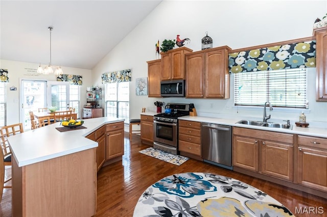221 Meriwether Lewis Dr, Ofallon, MO 63368 - kitchen featuring appliances with stainless steel finishes, high vaulted ceiling, dark wood-style floors, light countertops, and a breakfast bar