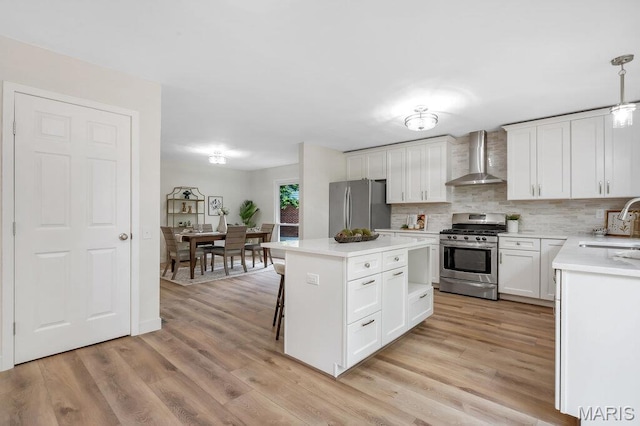 1254 Jade Wind Cir, Ballwin, MO 63011 - kitchen featuring stainless steel appliances, wall chimney exhaust hood, light countertops, a kitchen island, and tasteful backsplash