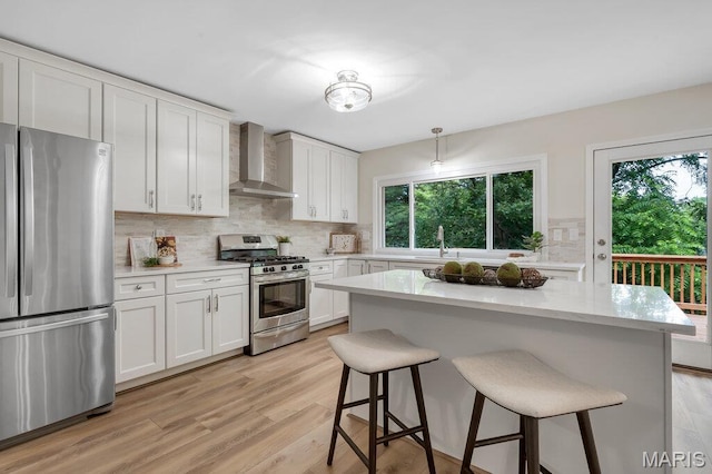 1254 Jade Wind Cir, Ballwin, MO 63011 - kitchen with stainless steel appliances, wall chimney range hood, a kitchen breakfast bar, and backsplash