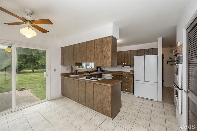 14898 Pheasant Hill Ct, Chesterfield, MO 63017 - kitchen featuring white appliances, a peninsula, light tile patterned floors, and plenty of natural light