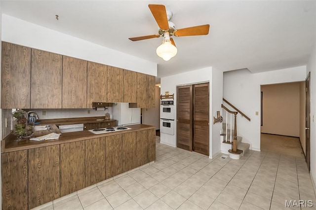 14898 Pheasant Hill Ct, Chesterfield, MO 63017 - kitchen with white appliances, ceiling fan, brown cabinets, a peninsula, and light tile patterned flooring