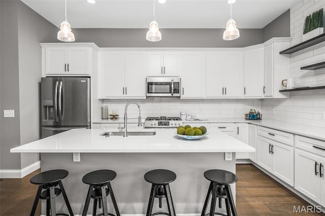 3400 Vista Ave, Saint Louis, MO 63104 - kitchen featuring appliances with stainless steel finishes, tasteful backsplash, a breakfast bar area, white cabinets, and recessed lighting