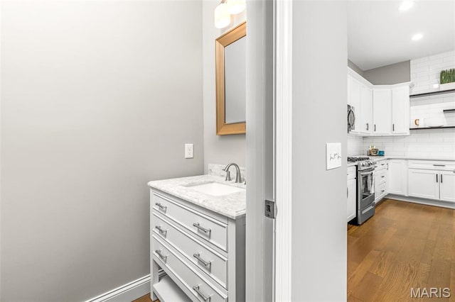 3400 Vista Ave, Saint Louis, MO 63104 - bathroom featuring backsplash, wood finished floors, recessed lighting, and vanity