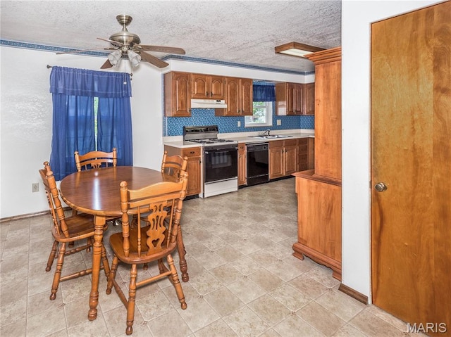 9 Richard St, Waterloo, IL 62298 - kitchen with gas stove, black dishwasher, under cabinet range hood, light countertops, and a textured ceiling