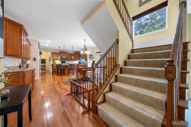 24 Milton Brennan Manor Ct, Wentzville, MO 63385 - staircase featuring hardwood / wood-style flooring, a chandelier, and recessed lighting