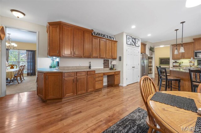 24 Milton Brennan Manor Ct, Wentzville, MO 63385 - kitchen featuring appliances with stainless steel finishes, light wood-style flooring, hanging light fixtures, a chandelier, and recessed lighting