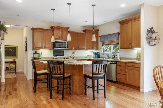 24 Milton Brennan Manor Ct, Wentzville, MO 63385 - kitchen with stainless steel appliances, brown cabinetry, light wood-style floors, and recessed lighting
