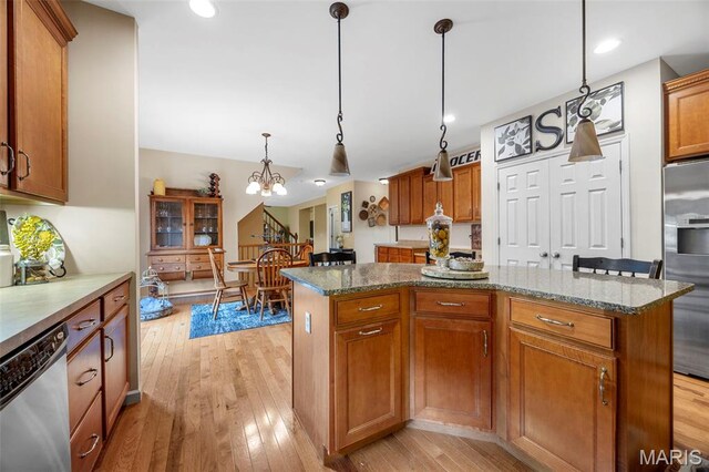 24 Milton Brennan Manor Ct, Wentzville, MO 63385 - kitchen with stainless steel appliances, light wood-style floors, a kitchen island, brown cabinets, and recessed lighting