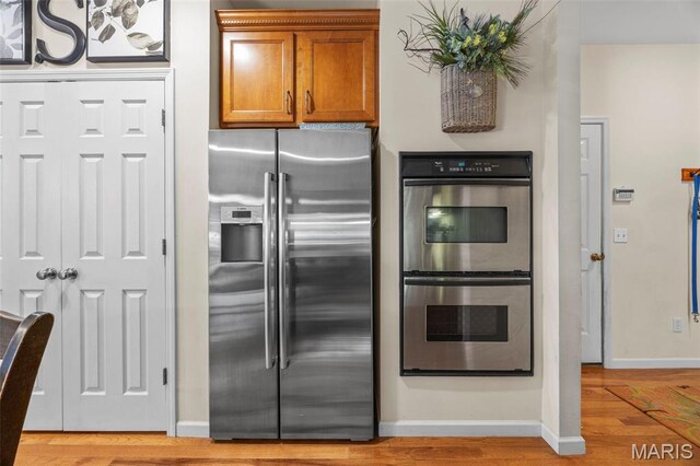 24 Milton Brennan Manor Ct, Wentzville, MO 63385 - kitchen featuring appliances with stainless steel finishes, brown cabinets, and light wood-style floors