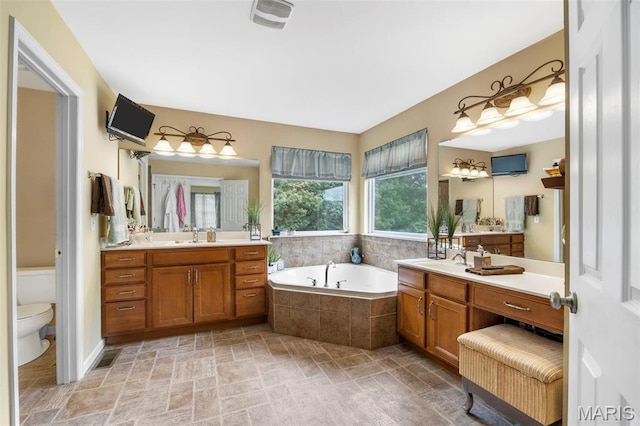 24 Milton Brennan Manor Ct, Wentzville, MO 63385 - bathroom with a garden tub, two vanities, and stone finish floors