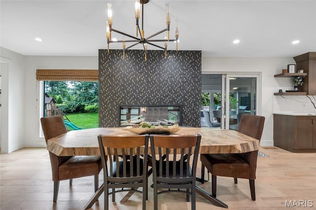 1607 Wyncliff Ln, Frontenac, MO 63131 - dining space featuring a multi sided fireplace, a chandelier, recessed lighting, and light wood-type flooring