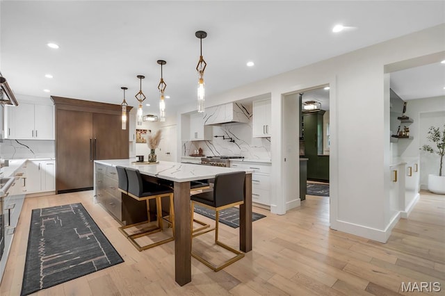 1607 Wyncliff Ln, Frontenac, MO 63131 - kitchen with premium range hood, backsplash, light wood finished floors, recessed lighting, and a spacious island