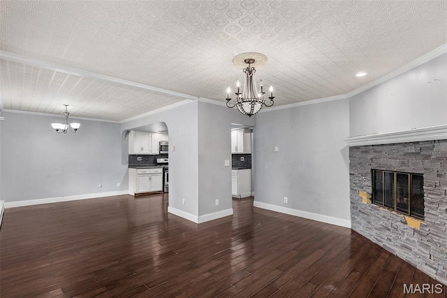 912 N Illinois Ave, Litchfield, IL 62056 - unfurnished living room with a chandelier, a stone fireplace, dark wood finished floors, arched walkways, and ornamental molding