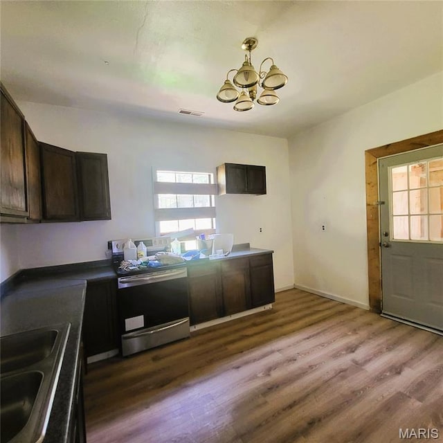 945 Cedar St, Poplar Bluff, MO 63901 - kitchen with stainless steel stove, a chandelier, wood finished floors, and dark brown cabinets
