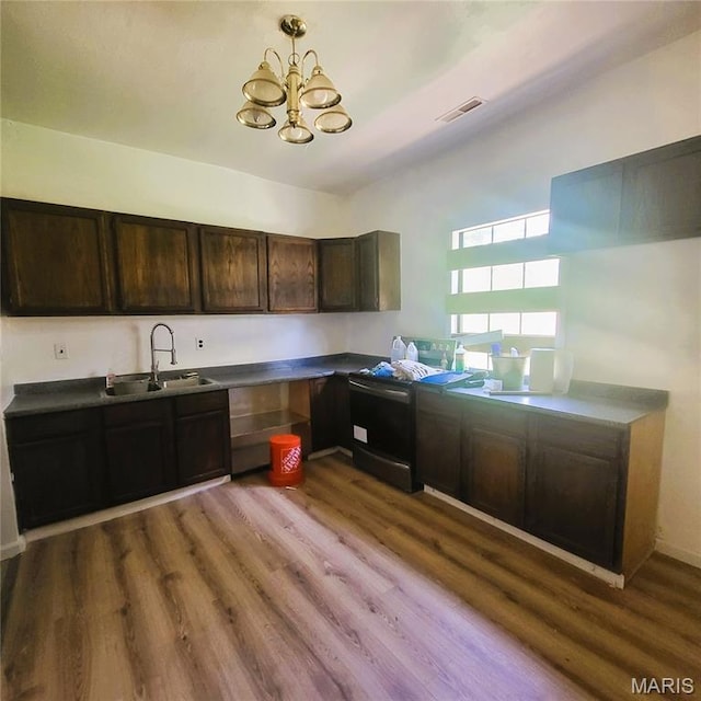 945 Cedar St, Poplar Bluff, MO 63901 - kitchen featuring stove, wood finished floors, a chandelier, dark brown cabinetry, and dark countertops