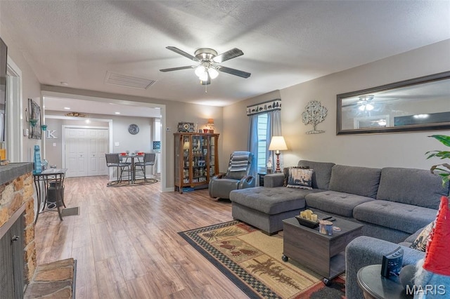 623 Boyne St, De Soto, MO 63020 - living area featuring a ceiling fan, wood finished floors, a textured ceiling, and a fireplace