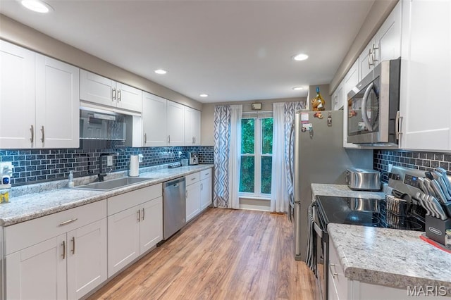 623 Boyne St, De Soto, MO 63020 - kitchen featuring appliances with stainless steel finishes, decorative backsplash, white cabinets, light wood-type flooring, and recessed lighting