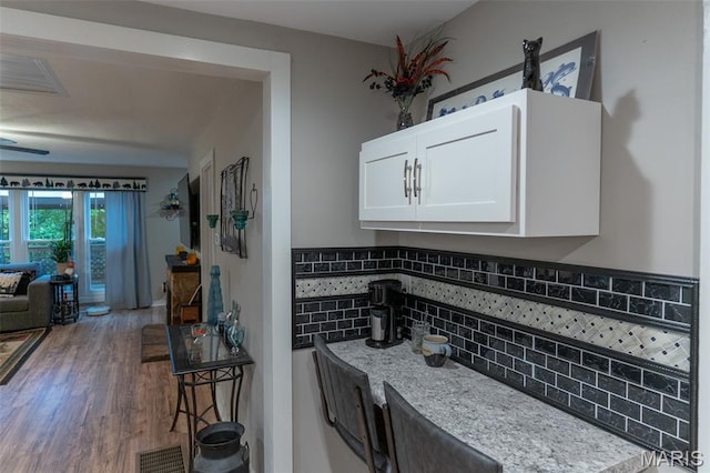 623 Boyne St, De Soto, MO 63020 - kitchen featuring white cabinetry, tasteful backsplash, and wood finished floors