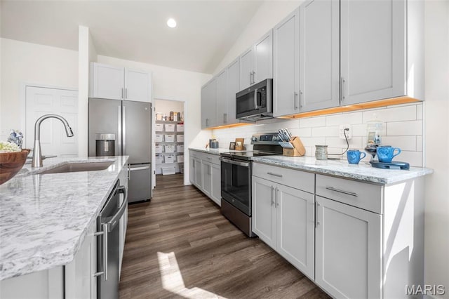 155 Pampano Ln, Saint Charles, MO 63301 - kitchen with appliances with stainless steel finishes, tasteful backsplash, dark wood-type flooring, light stone counters, and recessed lighting