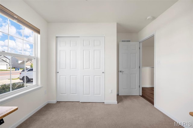 155 Pampano Ln, Saint Charles, MO 63301 - unfurnished bedroom with light carpet, multiple windows, and a closet