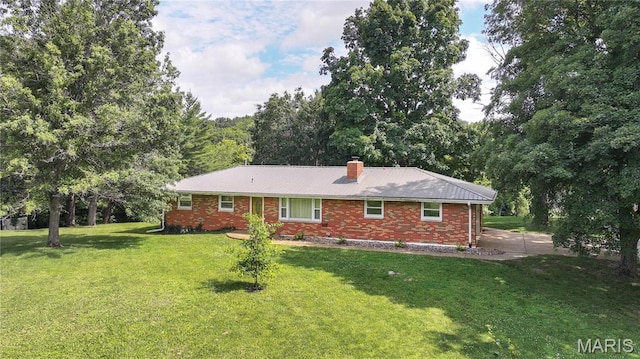 6155 Raymond Rd, Bunker Hill, IL 62014 - rear view of house with brick siding, a yard, a chimney, and a metal roof