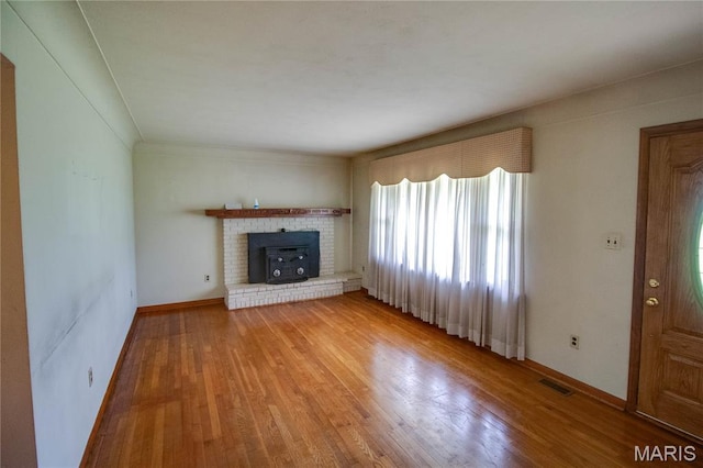 6155 Raymond Rd, Bunker Hill, IL 62014 - unfurnished living room with light wood-style floors and a brick fireplace