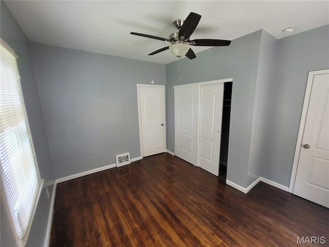 2965 Kincaid Ave, St John, MO 63114 - unfurnished bedroom featuring multiple windows, dark wood-style floors, a closet, and ceiling fan