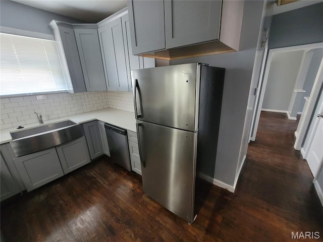 2965 Kincaid Ave, St John, MO 63114 - kitchen featuring stainless steel appliances, decorative backsplash, light countertops, and dark wood-style flooring