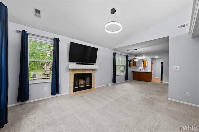 12107 Autumn Lakes Dr, Maryland Heights, MO 63043 - unfurnished living room with light carpet, lofted ceiling, plenty of natural light, and a tile fireplace