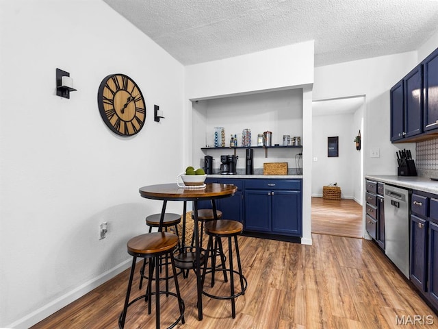 414 Plum St, Edwardsville, IL 62025 - kitchen featuring dishwasher, blue cabinets, wood finished floors, light countertops, and a textured ceiling