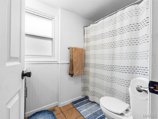 414 Plum St, Edwardsville, IL 62025 - full bathroom featuring a textured ceiling, tile patterned flooring, a shower with shower curtain, and wainscoting