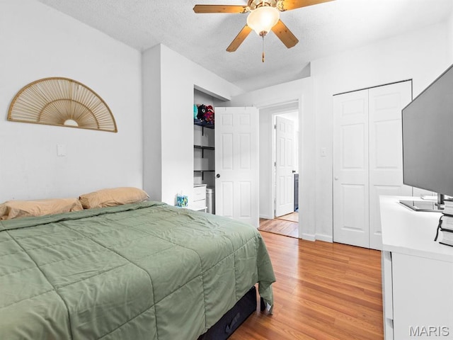 414 Plum St, Edwardsville, IL 62025 - bedroom with light wood-style flooring, a textured ceiling, two closets, and a ceiling fan