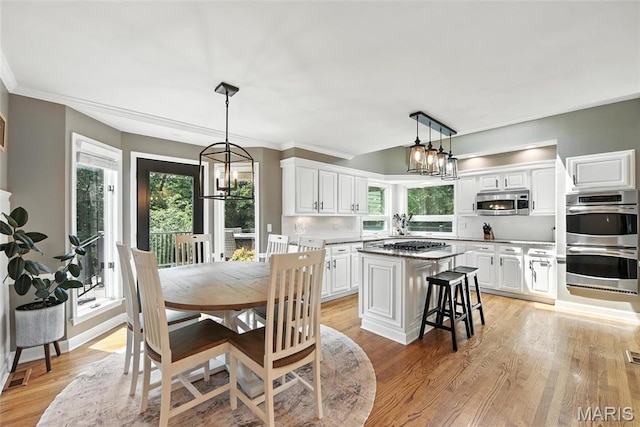 3 Morganfield Ct, Chesterfield, MO 63005 - dining space featuring a chandelier, healthy amount of natural light, light wood finished floors, and ornamental molding