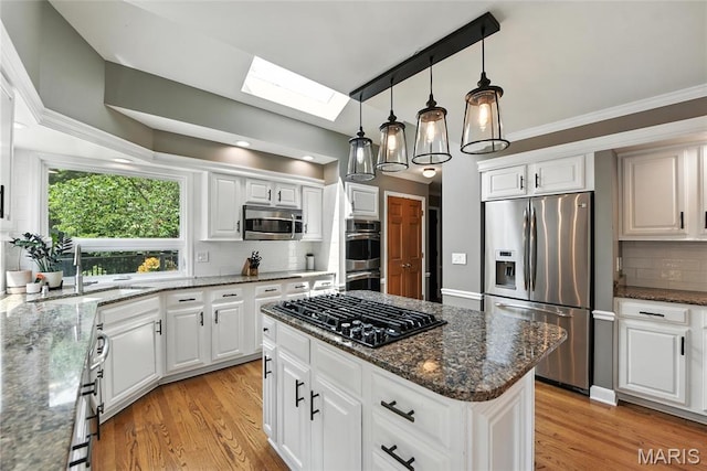 3 Morganfield Ct, Chesterfield, MO 63005 - kitchen featuring stainless steel appliances, a skylight, backsplash, light wood-style flooring, and ornamental molding