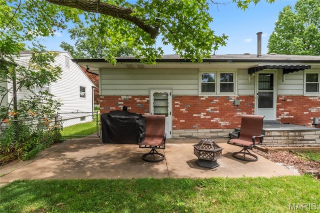 1140 Lindsay Ln, Florissant, MO 63031 - rear view of property with a fire pit, brick siding, and a patio