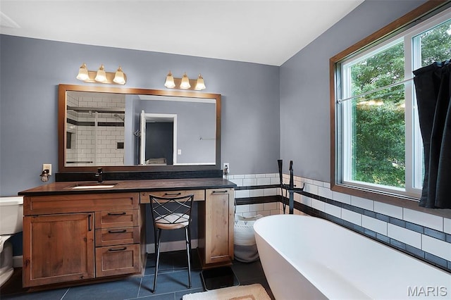 6232 Clover Lake Dr, Cedar Hill, MO 63016 - bathroom with a freestanding bath, vanity, tile patterned flooring, a wainscoted wall, and a shower