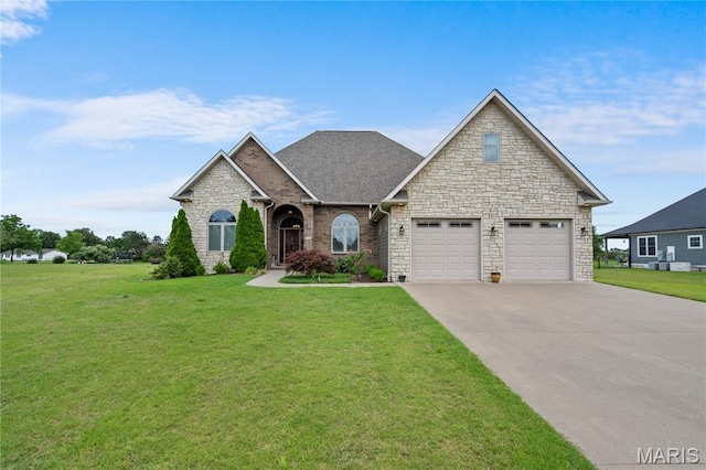 108 Jennings Ln, Sikeston, MO 63801 - view of front of home featuring stone siding, a front yard, driveway, and a garage