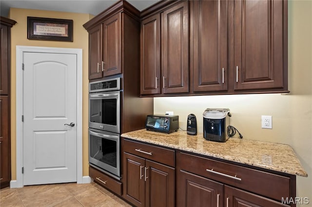 108 Jennings Ln, Sikeston, MO 63801 - kitchen featuring stainless steel double oven, light stone countertops, dark brown cabinets, and light tile patterned floors