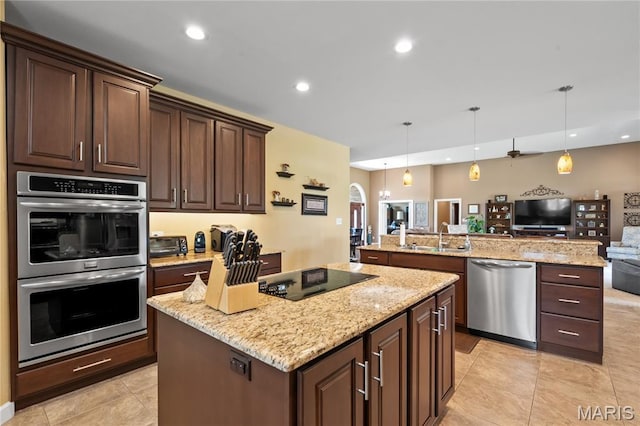 108 Jennings Ln, Sikeston, MO 63801 - kitchen with stainless steel appliances, open floor plan, a kitchen island, light stone counters, and light tile patterned floors