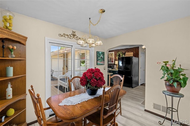 111 Freedom Dr, Belleville, IL 62226 - dining space with arched walkways, a chandelier, and light wood finished floors